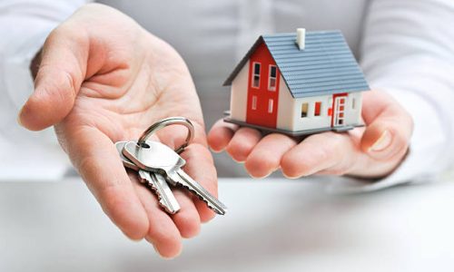 Real estate agent with house model and keys